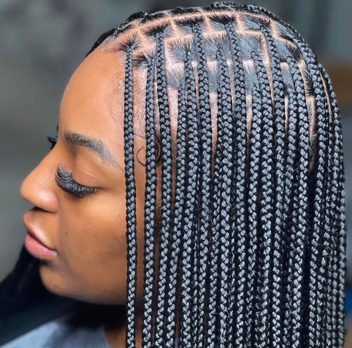 Client with long ginger box braids styled to one side